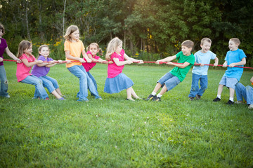 Obraz premium Girls Versus Boys Tug-of-War Team Game Outside