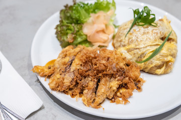 omelette rice served with fried sliced pork, Thai style mix Japanese food