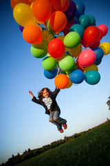 Happy Little Girl Holding Bunch of Balloons
