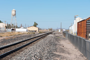 Railroad track in a village with commercial buildings and a water tower