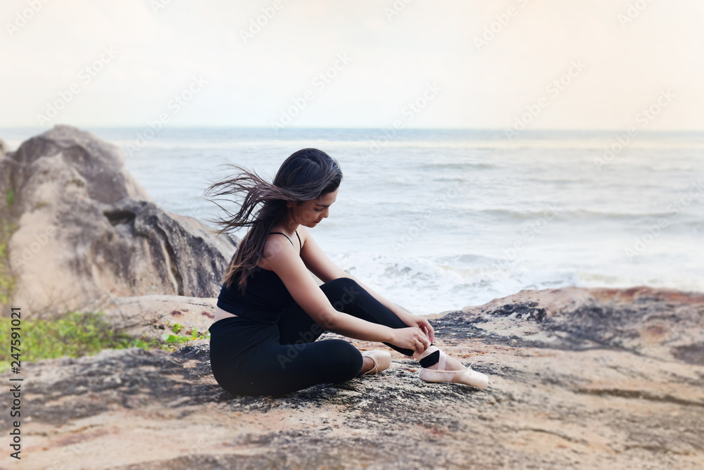 Wall mural in selective focus of beauty lady wearing black suit and satin ballet shoes,sitting on ground floor,