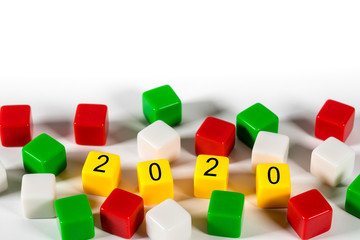 2020 spelled in blocks among other colorful dice on white background for New Years concept