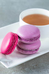 Photo of cake macarons, gift box, tea, coffee, cappuccino and flowers. Sweet romantic food macaroon concept. Morning breakfast and presents. Valentine's day concept.