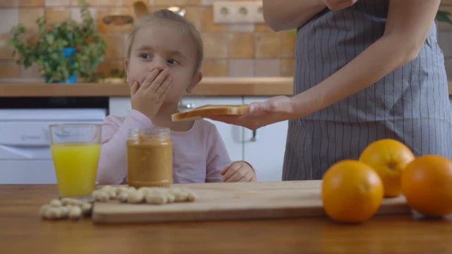 Cute kid girl not wanting to eat healthy food at kitchen