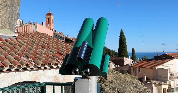 Tourist Coin Operated Binoculars At A Viewpoint In Roquebrune-Cap-Martin, Old French Medieval Village With Paragliding In The Blue Sky, Mediterranean Sea On The French Riviera, France, Europe - DCi 4K