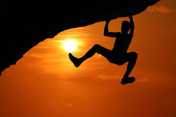 Free climbing on the mountain at red sky sunset background