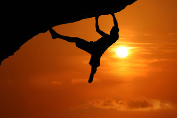 Free climbing on the mountain at red sky sunset background