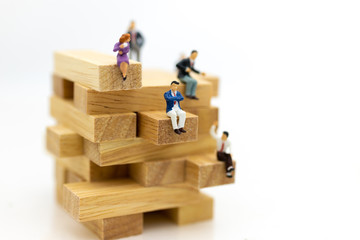 Miniature people: Business people sitting on puzzle pieces. Image use for find the answer of question, education , business concept.