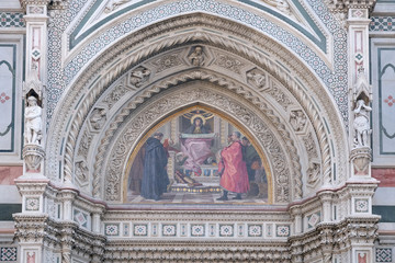 Fototapeta premium Charity among the founders of Florentine philanthropic institutions, Left Portal of Cattedrale di Santa Maria del Fiore, Florence, Italy 