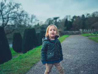 Fototapeta premium Little toddler in a formal garden