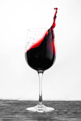Red wine in the glass splashes in motion on a white background. Design card