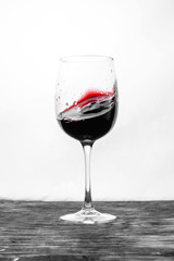 Red wine in the glass splashes in motion on a white background. Design card