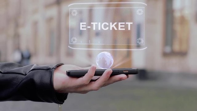 Male hands show on smartphone conceptual HUD hologram E-ticket. Man with the future technology mobile holographic screen on blurred background of the university
