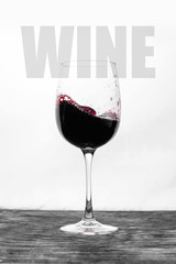 Red wine in the glass splashes in motion on a white background. Stylish design card with text