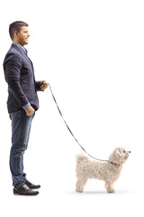 Young man standing with a maltese poodle dog