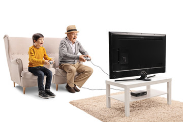 Grandfather and grandson playing video game in front of a TV