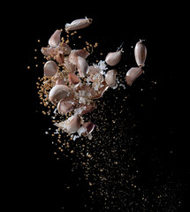 Garlic,various spices, pepper and salt splash or explosion flying in the air isolated on black,Stop...