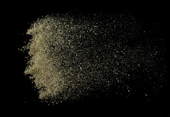 Oregano spice splash or explosion flying in the air isolated on black background,Motion blur