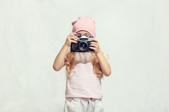 Little child girl is beautiful fashionable and happy with camera in hand on isolated background