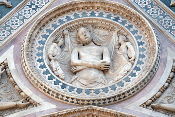 Wrapping Christ in his shroud, Portal on the side-wall of Cattedrale di Santa Maria del Fiore (Cathedral of Saint Mary of the Flower), Florence, Italy