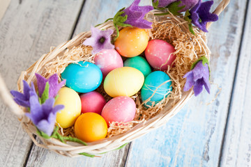 8822504 Easter eggs in a basket on a wooden table