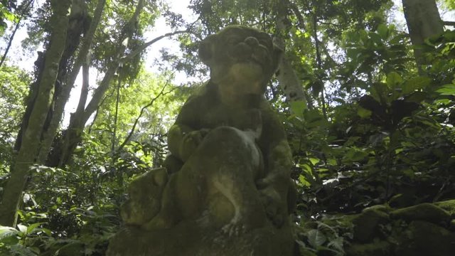 Handheld shot of two animal creature statue in the jungle, paws and face and buttock