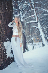 Fototapeta premium Winter Beauty Woman. Beautiful fashion model girl with snow hairstyle and makeup in the winter forest. Festive makeup and manicure. Winter Queen with snow and ice hairstyle