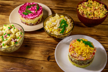 Set of festive mayonnaise salads on wooden table