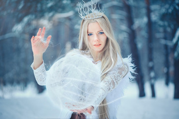 Winter Beauty Woman. Beautiful fashion model girl with snow hairstyle and makeup in the winter forest. Festive makeup and manicure. Winter Queen with snow and ice hairstyle. magic with snow