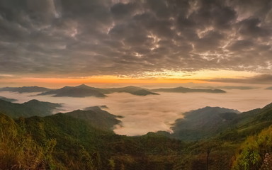 sunrise at Doi Pha Tang, beautiful mountain view morning panorama 180 degree of top hill around with sea of mist with yellow sun light and cloudy sky background, Chiang Rai, Thailand.