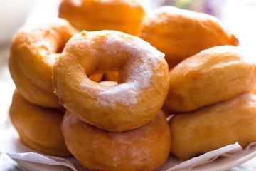 Hot confectioners have just been sentenced and laid out on dishes and sprinkled with powdered sugar. A very tasty flour product for lovers of dessert drinks and sweet treats.