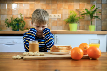 Cute kid girl not wanting to eat healthy food at kitchen - obrazy, fototapety, plakaty