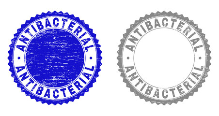 Obraz premium Grunge ANTIBACTERIAL stamp seals isolated on a white background. Rosette seals with grunge texture in blue and gray colors. Vector rubber watermark of ANTIBACTERIAL label inside round rosette.