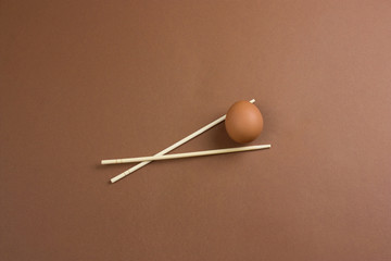 egg and wooden sticks on a brown background