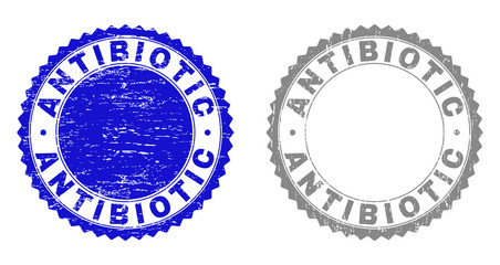 Grunge ANTIBIOTIC stamp seals isolated on a white background. Rosette seals with distress texture in blue and grey colors. Vector rubber imitation of ANTIBIOTIC text inside round rosette.