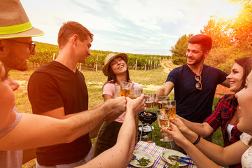 happy people celebrate birthday of their friends during picnic in the vineyard
