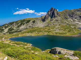 Naklejka na ściany i meble Bulgarian Rila Mountains August view of the Twin Lake or Bliznaka and Haramijata Peak, also known as Hajduta Peak on a sunny summer day