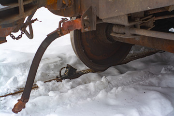 Freight car is parked on the parking brake in the middle of the snow on the railway.