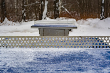 Outdoor ping pong table covered with snow in winter