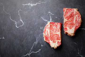  Raw Fresh Marbled Meat Beef Steak on the black marble Background Top View Copy space for Text