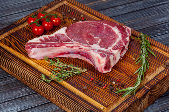  beautiful and juicy raw steak on the table with ingredients ready to roast