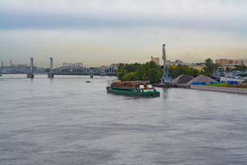 Cargo ship loaded with logs moving away from the cargo port