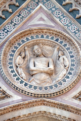 Fototapeta na wymiar Wrapping Christ in his shroud, Portal on the side-wall of Cattedrale di Santa Maria del Fiore (Cathedral of Saint Mary of the Flower), Florence, Italy 