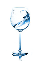 Blue splashes of clean water in the wine glass. A spray of water. Drinking water.