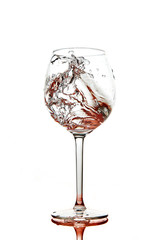 Red splashes of clean water in the wine glass. A spray of water. Drinking water.