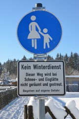 Hinweisschild am Weg in verschneiter Winterlandschaft - Kein Winterdienst - Schnee