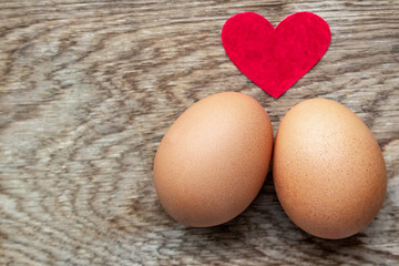 Two eggs with red heart on wooden background with Valentines day concept