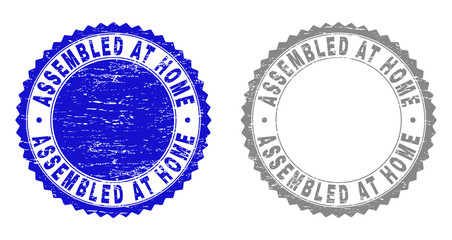 Grunge ASSEMBLED AT HOME stamp seals isolated on a white background. Rosette seals with grunge texture in blue and grey colors. Vector rubber imprint of ASSEMBLED AT HOME label inside round rosette.