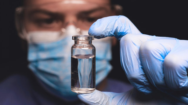 Laboratory worker scientist laboratory assistant tests chemicals for reactions in test tubes, interfering with different substances and obtaining a visual reaction. Concept of: Science, Chemistry.