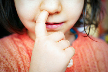 child with a finger in his nose